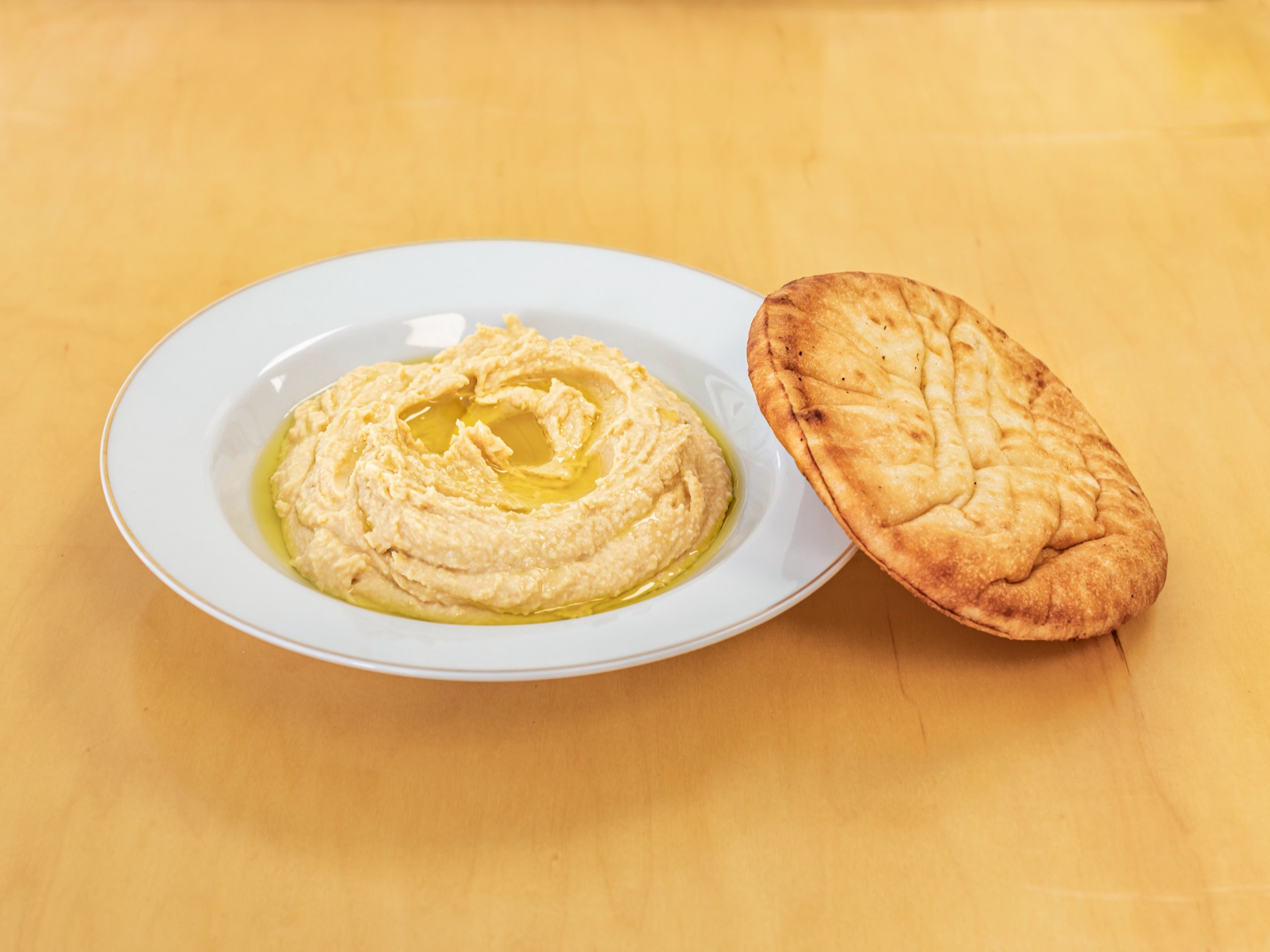 Hummus finished with olive oil, with a round of pita